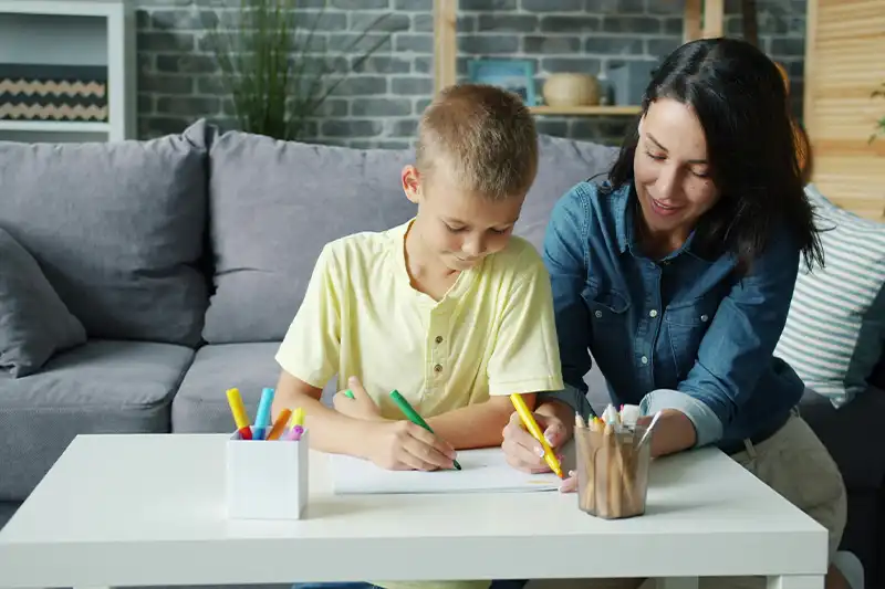 Parent helping child with autism follow a structured home schedule using visual aids