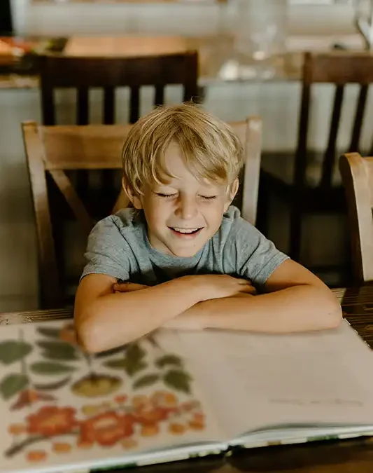 Child with autism using a token board while parent offers encouragement